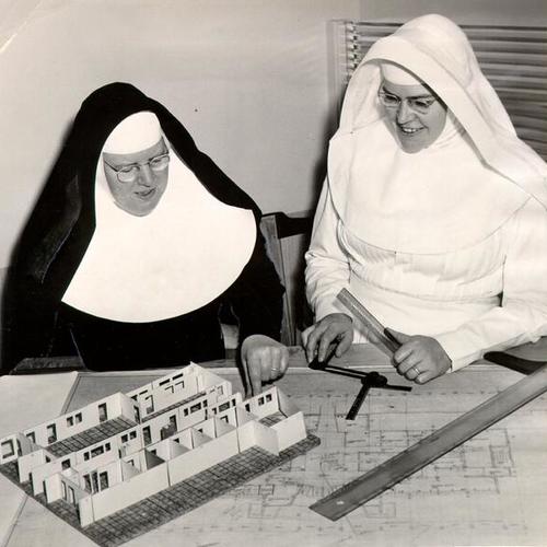 [Sister Mary Philippa and Sister Mary Pius looking at architectural plans for St. Mary's Hospital]