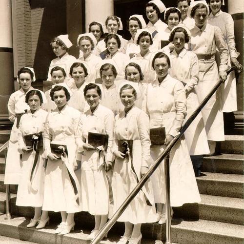 [Graduates posing with their diplomas at Mary's Help School of Nursing]
