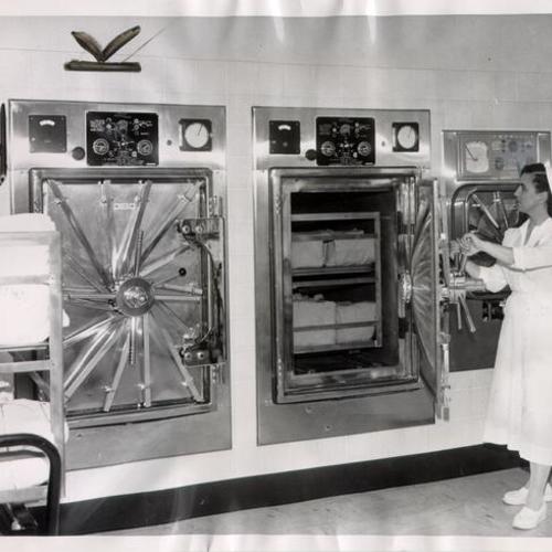 [Nurse Joseph Flohr demonstrating a new steam sterilizer at St. Francis Memorial Hospital]