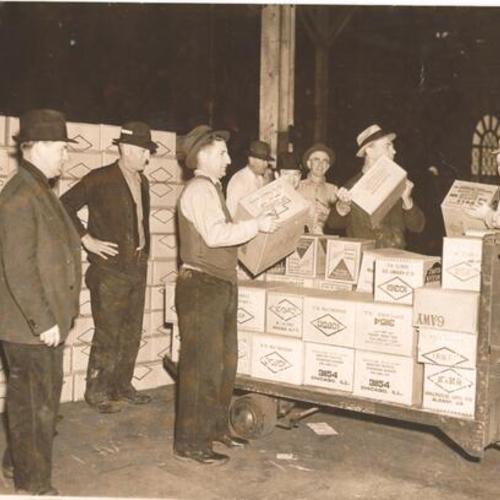 [Group of men loading boxes at the waterfront]