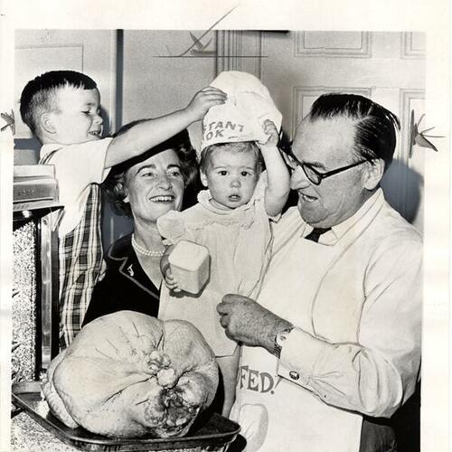 [Governor Edmund G. Brown and family looking over Thanksgiving turkey]