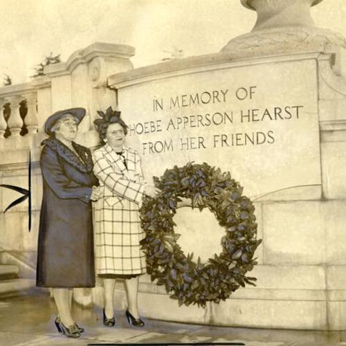 [Mrs. George Beanston and Mrs. J. E. Finley placing a wreath on the monument to Phoebe Apperson Hearst in Golden Gate Park]