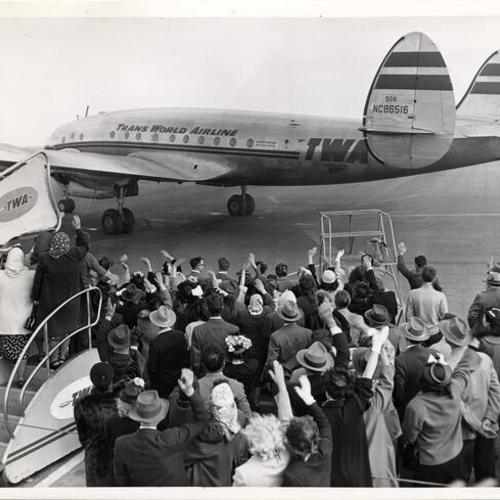 [Group of people watching TWA airplane leave airport]