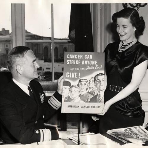 [Rear Admiral Lynde D. McCormick accepting a placard from Mrs. John Kearney, Jr. in recognition of the Navy's backing of the American Cancer Society's 1949 program]