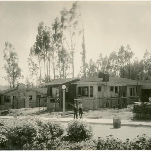 [Two unidentified boys skating in front of unfinished houses in Westwood Park]