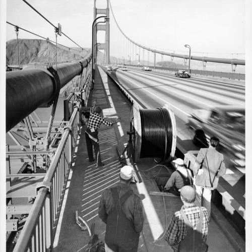 [Hokin and Gavin electrical contractors laying cable across the Golden Gate Bridge]