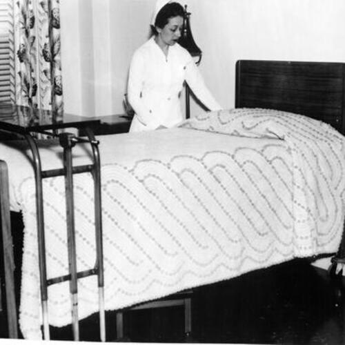 [Hahnemann Hospital nurse making bed]