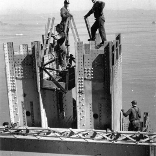 [Construction workers at top of Golden Gate Bridge north tower]