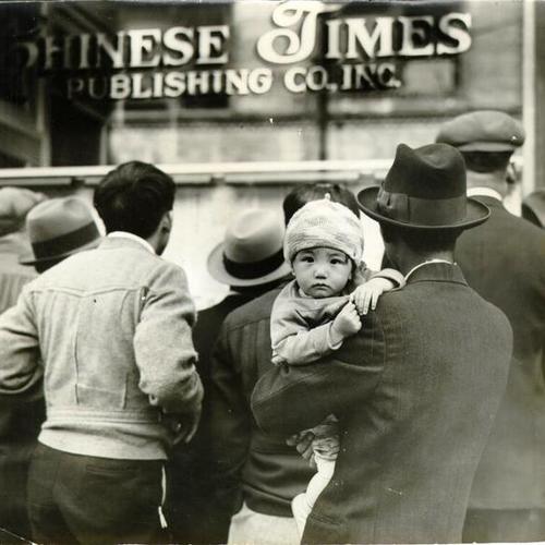 [Group of people reading notices in front of the Chinese Times Publishing Co, Inc. in Chinatown]