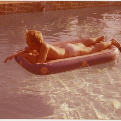 Bob Burkhart, nude, laying on inflatable in pool at Rock Hudson's home, The Castle, Beverly Hills