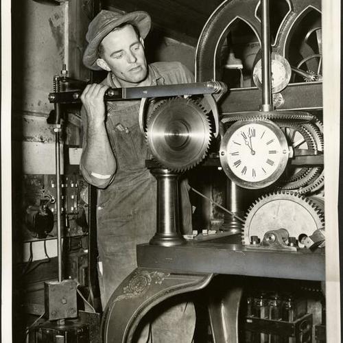 [Technician Harold Bush working with machinery inside Ferry Building clock]