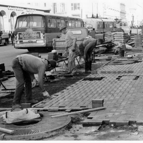 [Construction workers laying brick along the sidewalks of Market Street]
