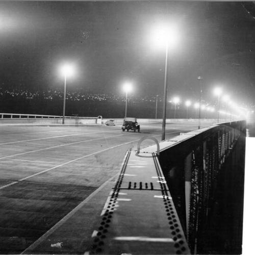 [Night view of motorist passing through upper deck of San Francisco-Oakland Bay Bridge cantilever highway span]