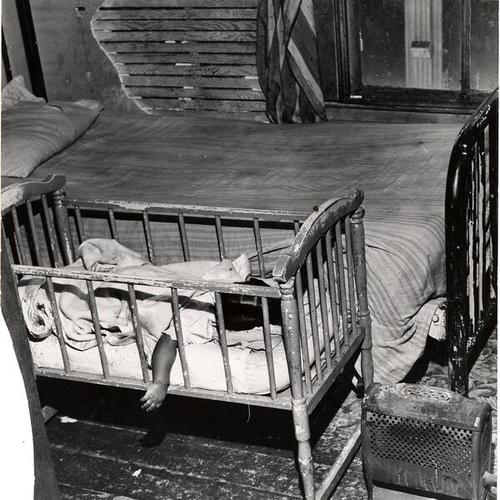 [Sleeping child in crib at an unidentified home on Geary St.]