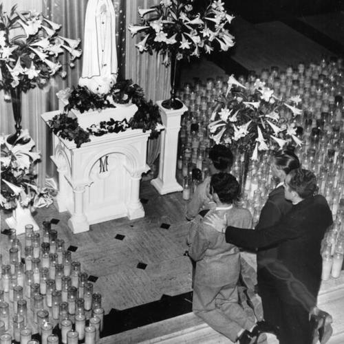 [Three young men kneeling in front of an altar with Father Thomas Regan in Old St. Mary's Cathedral]