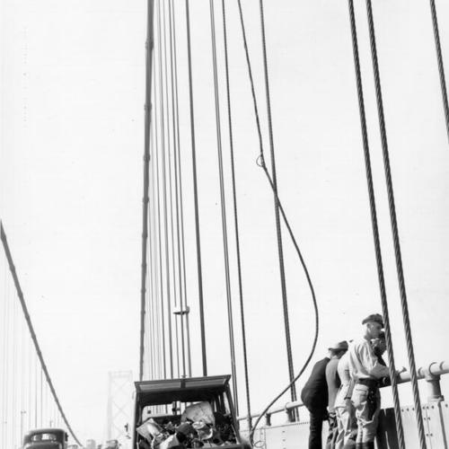 [Group of Navy men standing at the spot that a Navy plane crashed into the San Francisco-Oakland Bay Bridge]