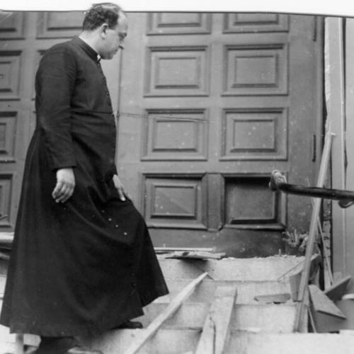 [Father Trincherri looking at bomb damage at Saints Peter and Paul's Church]