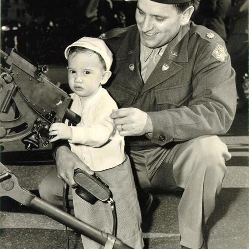 [Major Jerome Ingerski showing his son a machine gun]