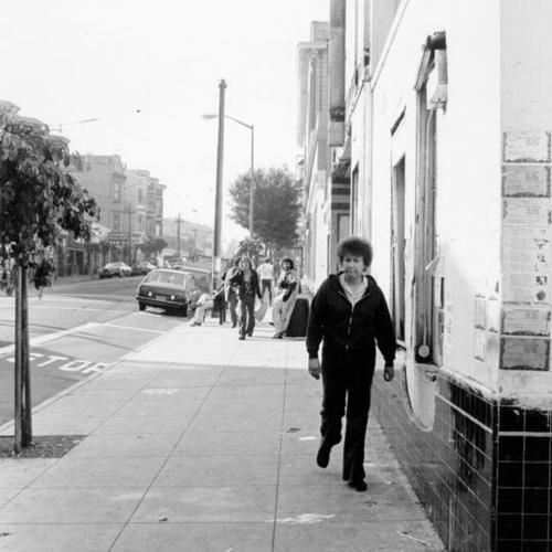 [Woman walking by the Haight Street Theater on Haight Street at Cole]