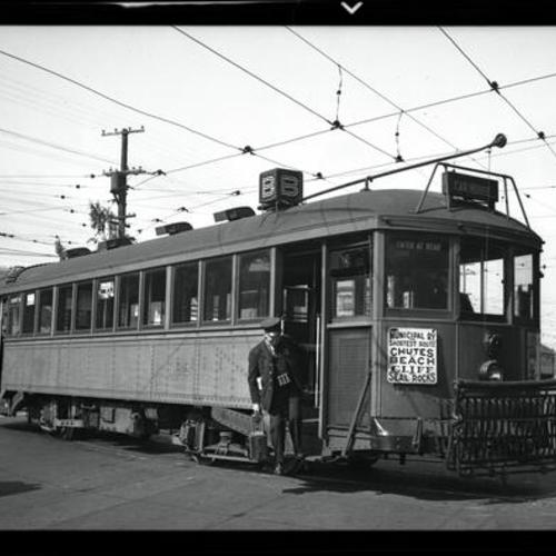 [Conductor carrying farebox off of "B" line car 192 at Geary carhouse]