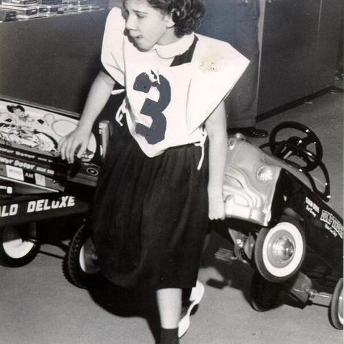 [Brenda Lee Croat dragging a toy truck during a 3 1/2 minute "toy roundup" at Macy's department store]