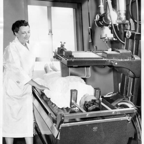 [Technician Mary Findlay and student nurse Noel Hurd demonstrating a new X-Ray unit at St. Luke's Hospital]