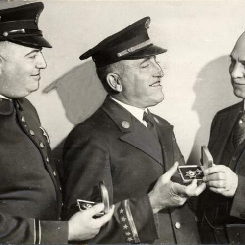 [Unidentified Officer, Officer James Shanohan being presented with medal by Mayor Angelo Rossi]