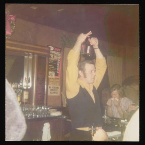 Bartender holding up beer bottles at Christmas party
