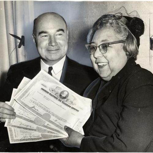 [Mrs. Gladys Stevens and attorney Bergen Van Brunt holding shares of stock turned over to her]