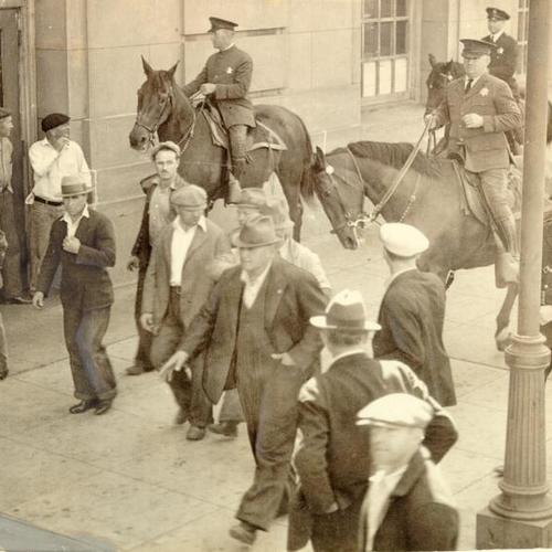 [Police officers on horses controlling crowd during Longshoremen's Strike at waterfront]