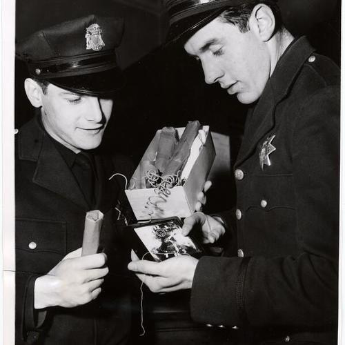 [Officers Anatole Balmy and John Wydler examining a "phony" bomb]