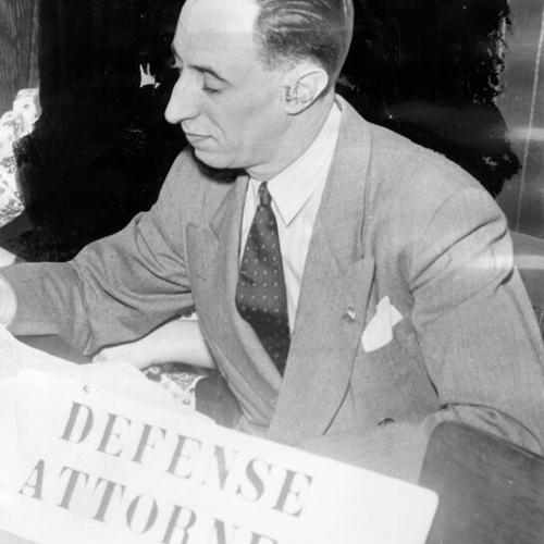 [Harry Bridges seated at table with sign that reads "Defense Attorneys"]