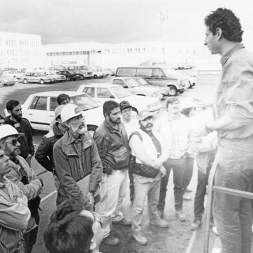 [Work crew conduction a meeting in parking lot during aftermath of  Loma Prieta earthquake]