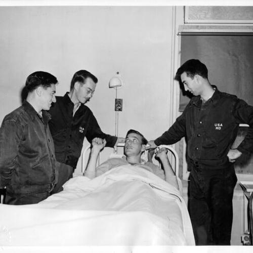 [Four soldiers talking in the malaria ward at Letterman General Hospital]