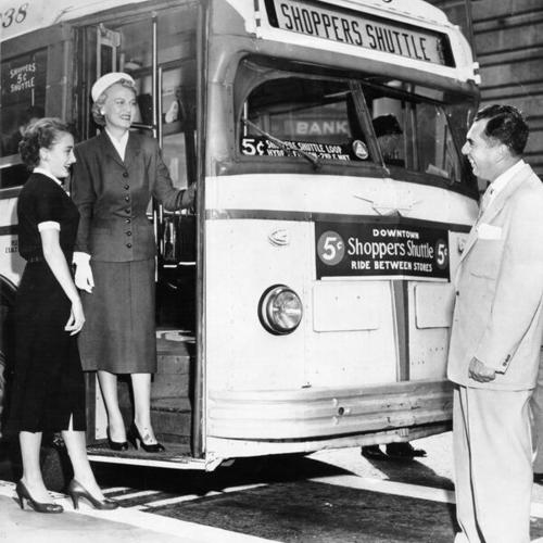 [Carol Woods and Agnes Madsen boarding 'Shopper Shuttle' bus]