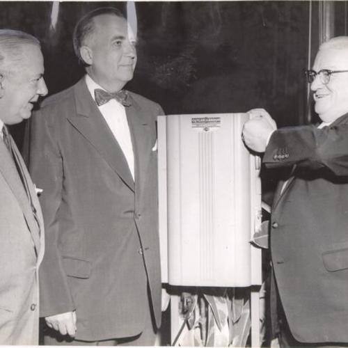 [Mayor Elmer Robinson throwing the switch to light the giant beer glass sign atop the Hamm's Brewery on Bryant Street]