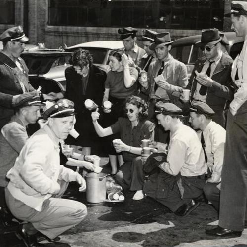 [Striking employees of the Pacific Greyhound Bus Company eating lunches provided by their wives on picket line at 17th and Arkansas streets]