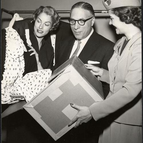[Cathy Raymond, Cyril Magnin and Claire Jaygood inspecting a shipment of merchandise prior to the opening of the Joseph Magnin store at Stonestown]