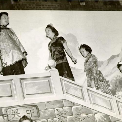 [Amy Chin, Laura Wong, Patricia Joe and Ruth Wong walking up staircase in front of backdrop]