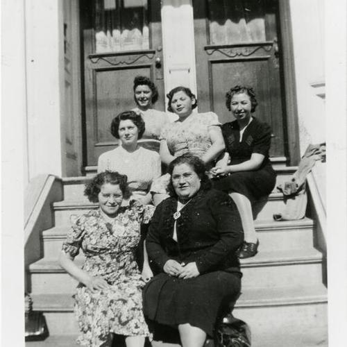[Sisters and friends sitting on steps at Scott Street]