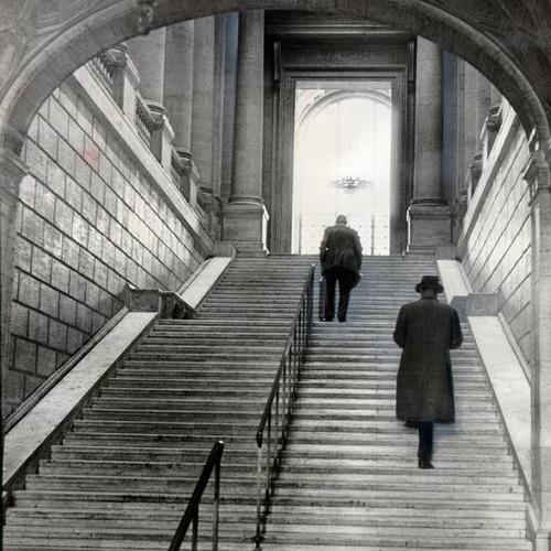 [Two people ascending the staircase at the Main Library]