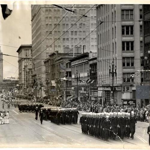 [Parade of Navy men striding up Market Street]