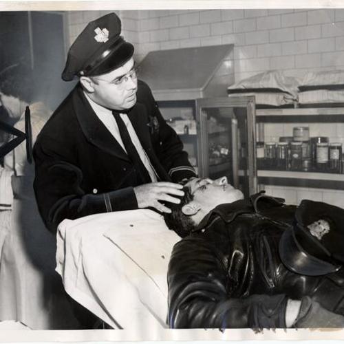 [Steward James Flanagan assisting Officer Robert C. Wilson in a hospital facility]