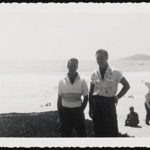 Two people standing at the beach