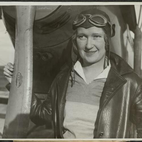 Maxine Dunlap standing in front of plane with hand on propeller