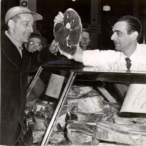 [Butcher Mike Bersaglieri awarding J. D. Ellis a free steak for being the first in line to buy New Zealand beef from Annex Market at 1029 Market Street]