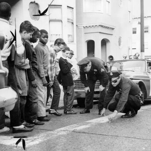 [Police Sgt. Louis Sevenau and Patrolman Richard Silva marking off the spot on Haight Street where 7 year old David Geddes was hit by a bus]