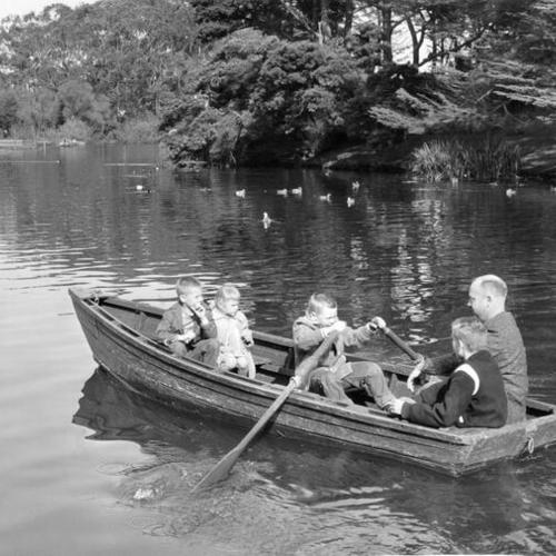 [A family taking a ride in a rowboat on Stow Lake in Golden Gate Park]