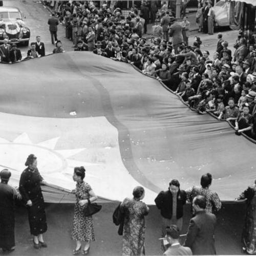 [Giant flag of the Chinese Republic being carried down Grant Avenue in observance of China's Double Ten Day]