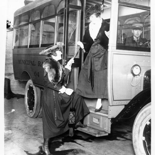 [Two women standing at the entrance to an early Muni bus]